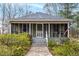 Charming home featuring a cozy, screened-in front porch and lush landscaping at 204 Morris St, Palmetto, GA 30268