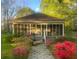 Charming home with a screened-in porch, lush flowers, and a stone walkway at 204 Morris St, Palmetto, GA 30268