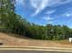 Land lot surrounded by lush trees, ready for your dream home with an easy connection to city water, sewer, and natural gas at 3560 Sky Ln, Cumming, GA 30041