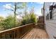 Wooden deck, with railing, showcases lush green trees, and plants, surrounding the home at 4139 Torver Ln, Atlanta, GA 30341