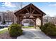 Community entrance with wooden pergola, shrubs and view of townhomes and garages at 4139 Torver Ln, Atlanta, GA 30341