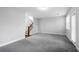 Large, bright living room with gray carpet, white walls, and wood stairs at 4139 Torver Ln, Atlanta, GA 30341