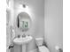 Neutral powder room with a pedestal sink, commode, oval mirror, and window at 4139 Torver Ln, Atlanta, GA 30341
