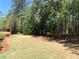 Expansive backyard featuring a well-maintained lawn, mature trees, and a charming wooden deck at 517 Mary Margaret Walk, Loganville, GA 30052