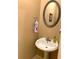 Half bathroom with a pedestal sink, oval mirror, and modern fixtures at 517 Mary Margaret Walk, Loganville, GA 30052