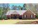 Charming brick home with a well-manicured lawn, mature trees, and a welcoming front entrance at 517 Mary Margaret Walk, Loganville, GA 30052