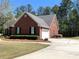 Brick home featuring a two-car garage, driveway, manicured shrubs and a well-maintained lawn at 517 Mary Margaret Walk, Loganville, GA 30052