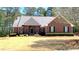 Charming brick home with a well-manicured lawn, mature trees, and a welcoming front entrance at 517 Mary Margaret Walk, Loganville, GA 30052