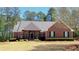 Charming brick home with a well-manicured lawn, mature trees, and a welcoming front entrance at 517 Mary Margaret Walk, Loganville, GA 30052