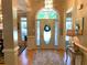 Bright foyer boasts hardwood floors, a decorative rug, and a beautiful front door with sidelights and transom window at 517 Mary Margaret Walk, Loganville, GA 30052