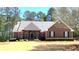 Beautiful brick home featuring a well-manicured lawn and a classic design with dark shutters and arched entry at 517 Mary Margaret Walk, Loganville, GA 30052