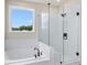Bright bathroom showcasing a soaking tub with tile surround and a glass enclosed shower at 722 Crossroad Ct, Powder Springs, GA 30127
