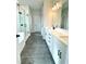 Bathroom with a glass shower, soaker tub, dual vanity sinks, and stylish dark marble floors at 722 Crossroad Ct, Powder Springs, GA 30127