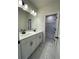 Bathroom with dual sinks, modern fixtures, and marble floors with an attached shower area at 722 Crossroad Ct, Powder Springs, GA 30127