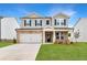 Charming two-story home with gray siding, stone accents, a well-manicured lawn, and a two car garage at 722 Crossroad Ct, Powder Springs, GA 30127
