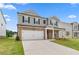 Inviting two-story home with gray siding, stone accents, well-manicured lawn, and a two car garage at 722 Crossroad Ct, Powder Springs, GA 30127