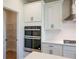 Modern kitchen with white cabinets, quartz countertops, and a walk-in pantry at 722 Crossroad Ct, Powder Springs, GA 30127