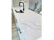 Close-up of kitchen island with white quartz countertop, black faucet, stainless steel sink, and modern cabinets at 722 Crossroad Ct, Powder Springs, GA 30127