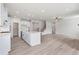 Open-concept living space with modern kitchen, light-colored flooring, and ample natural light at 722 Crossroad Ct, Powder Springs, GA 30127
