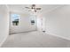 Sunlit main bedroom with plush carpeting, ceiling fan, and views of outside at 722 Crossroad Ct, Powder Springs, GA 30127