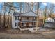 Two-story house with white siding, a wraparound porch, and a wooded backdrop at 3873 Wintergreen Ct, Marietta, GA 30062