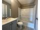 Clean bathroom, featuring a shower/tub combo, toilet, and vanity with gray cabinets at 3116 Leyland Ct, Decatur, GA 30034