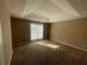 Spacious main bedroom with a tray ceiling, brown carpet, and large window at 3116 Leyland Ct, Decatur, GA 30034