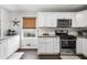 White kitchen features granite countertops, stainless steel appliances, and white shaker cabinets at 326 Scarlett Ln, Woodstock, GA 30188