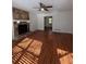 Living room with hardwood floors, stone fireplace and ceiling fan at 5250 Mountain Village Ct, Stone Mountain, GA 30083