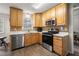 This kitchen has wood cabinets, stainless steel appliances, and wood-look tile flooring at 1867 Falcon Wood Ne Dr, Marietta, GA 30066