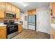 View of the kitchen with wood cabinets, stainless steel oven and blue refrigerator at 1867 Falcon Wood Ne Dr, Marietta, GA 30066