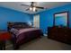 Bright bedroom with blue walls, ceiling fan, and dark wood furniture, creating a relaxing environment at 4417 Green Pastures Way, Ellenwood, GA 30294