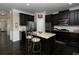 Well-equipped kitchen featuring dark cabinets, granite island, stainless appliances, and hardwood floors at 4417 Green Pastures Way, Ellenwood, GA 30294