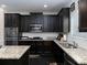 Well-equipped kitchen featuring granite countertops and sleek, dark wood cabinetry at 4417 Green Pastures Way, Ellenwood, GA 30294