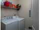 Functional laundry room with washer, dryer, and shelving for storage, maximizing space and convenience at 4417 Green Pastures Way, Ellenwood, GA 30294