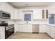 Modern kitchen with white cabinets and stainless steel appliances at 1650 Willow Way, Woodstock, GA 30188