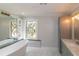 Elegant bathroom with soaking tub, marble tile, and stained glass window at 1907 Old Loganville Rd, Loganville, GA 30052