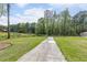 Long driveway leading to a home with a barn and trees at 1907 Old Loganville Rd, Loganville, GA 30052