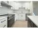 Modern kitchen with white cabinets, quartz countertops, and stainless steel appliances at 517 Stonehedge Dr, Stone Mountain, GA 30087