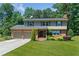 Charming two-story brick home with a manicured lawn, mature trees, and an attached two-car garage at 647 Shannon Green Cir, Mableton, GA 30126
