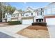 Three townhouses with attached garages and manicured landscaping in a suburban setting at 704 Woodland, Woodstock, GA 30188