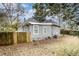 Grey home with a backyard that includes a wood fence, sparse vegetation, and bare trees at 118 Strickland St, Fairburn, GA 30213