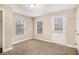 Bedroom with neutral carpet, two windows, and an exterior door at 118 Strickland St, Fairburn, GA 30213