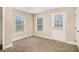 Bedroom with neutral walls, plush carpeting, and a door leading outside at 118 Strickland St, Fairburn, GA 30213