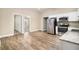 Bright kitchen features stainless steel appliances, white cabinets and granite countertops, with wood flooring and neutral paint at 118 Strickland St, Fairburn, GA 30213