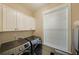 Bright laundry room featuring white cabinets, a window, and a modern washer and dryer at 1461 Thomas St, Conyers, GA 30094