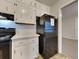 Bright kitchen with white cabinets and stainless steel appliances including a black refrigerator at 1581 Wesley Nw Way, Conyers, GA 30012