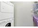 Modern laundry room featuring a stacked washer and dryer with overhead shelving at 2732 Wander Ln, Alpharetta, GA 30022