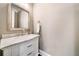 Stylish half-bath with a marble countertop vanity, designer mirror, and neutral wall color at 1545 Camden Cove Dr, Cumming, GA 30040