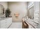 Bathroom vanity area with granite countertop, white cabinetry, and decorative mirror at 1545 Camden Cove Dr, Cumming, GA 30040
